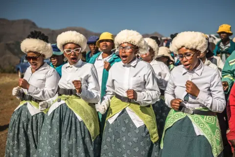 BRIAN OTIENO / GETTY IMAGES Women dressed in matching clothes stand together, singing and dancing - Wednesday 2 October 2024