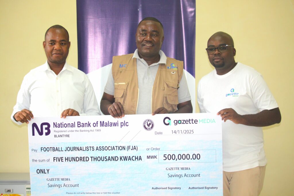 chapalapata (middle) handing over the cheque to frederich (left) flanked by gazette