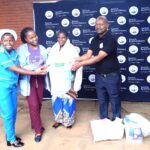 valera (right) handing over some of the items to zoto (far left) flanked by other beneficiaries (002)