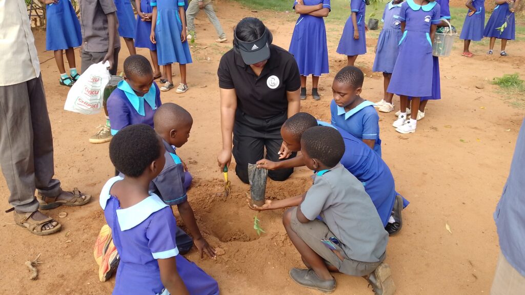 chilima teaches the pupils how to plant trees