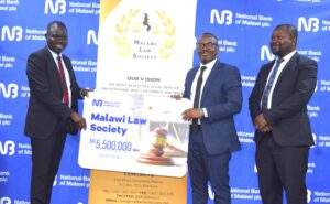 Sayenda (Left) handing over a dummy cheque to Kumwenda flanked by another MLS official (002)