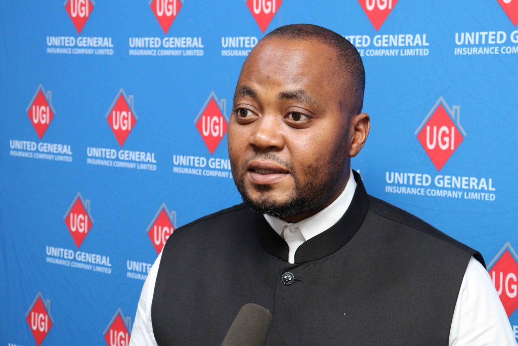 UGI Chief Operations Officer McDonald Chibwe speaking in front of a United General Insurance backdrop