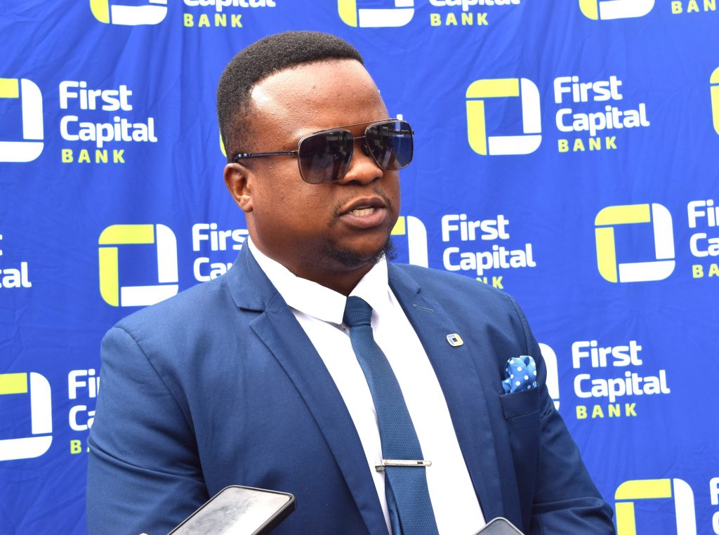 Twikale Chirwa speaking at the FCB Padel Cup launch in front of a First Capital Bank backdrop
