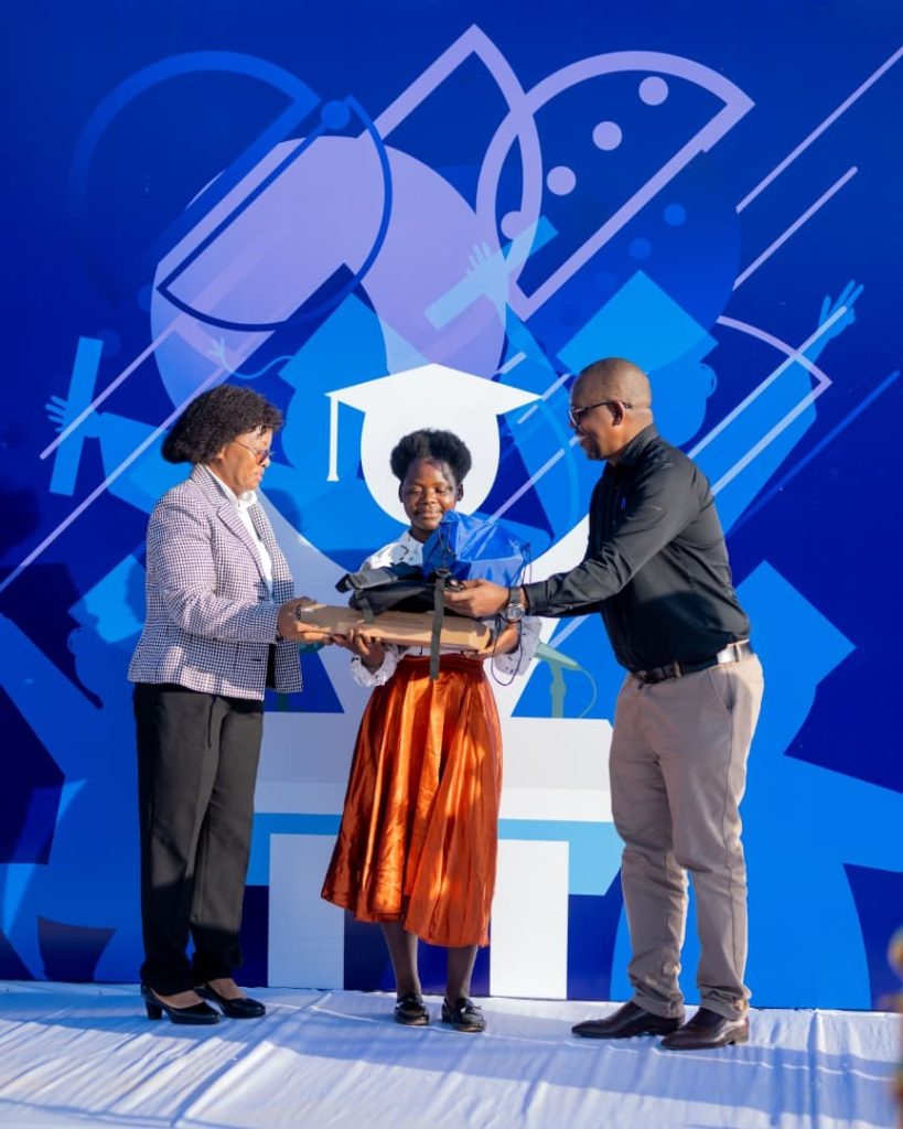 NBM and Mzuni officials presenting a laptop and bag to a student at the Mo Excellence Programme event