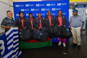 Chimwemwe Chijere NBM plc Business Development Manager Right posing for a picture with the Womens Team squad at KIA alongside an official from the team 002