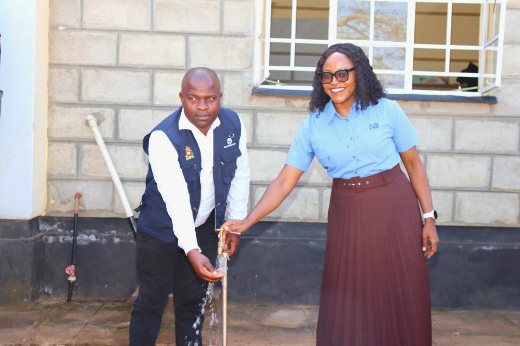 NBM officials turn on a tap at Mikate Health Post to provide clean water