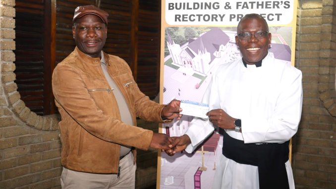 Jiya (Left) presenting the cheque to Father Kantembe (002)