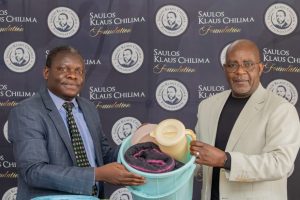 Mkwambisi (right) making a symbolic presentation of some of the items to Mwafongo