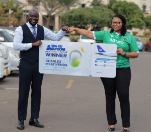 NBM plc flies three to WAFCON | Malawi Freedom Network Mphepo Hiwa Right handing over a dummy air ticket to Msatiyenda 002 scaled