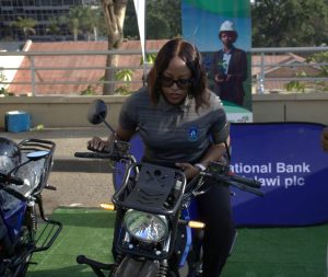 NBM plc expands fleet with EV and e-bikes | Malawi Freedom Network NBM plc Relationship Manager Rachel Chirambo testing the e bike 002 300x253